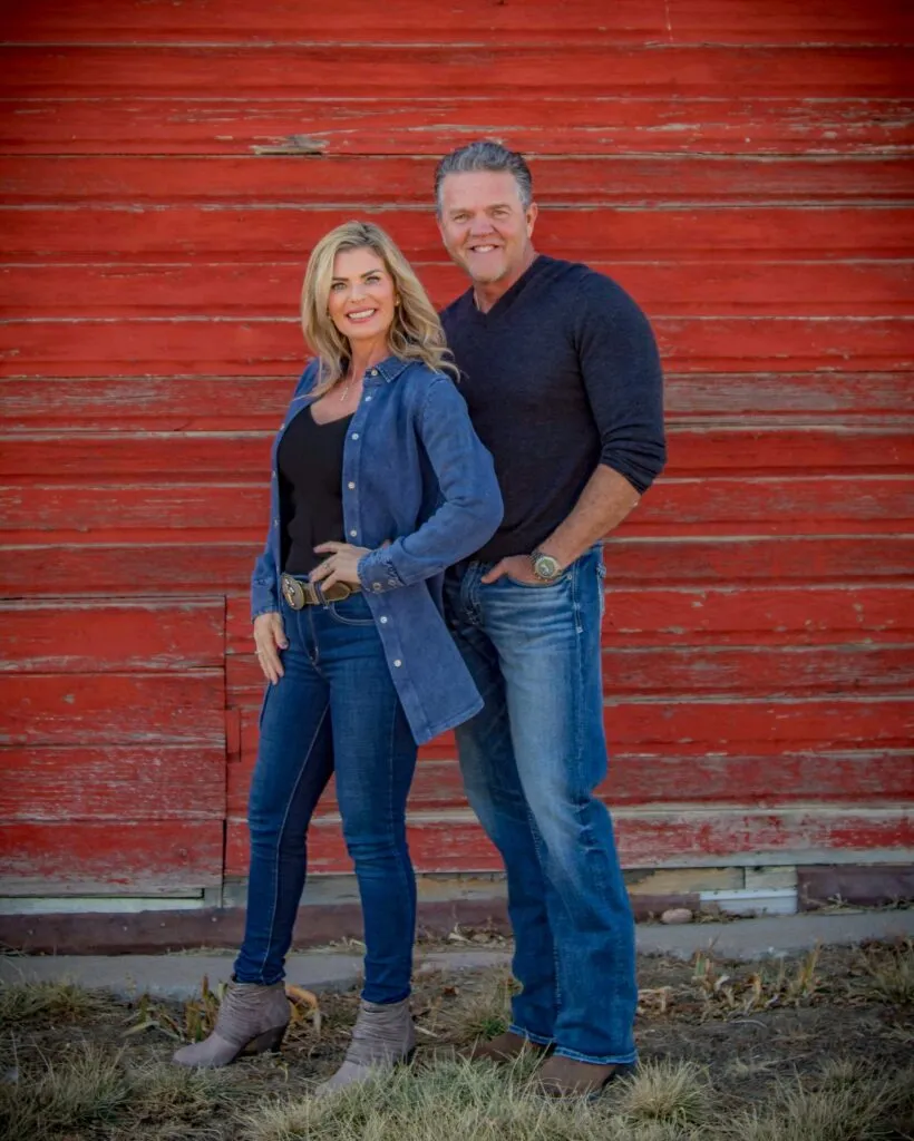 Jeff and Misty Garman standing together in front of a red barn